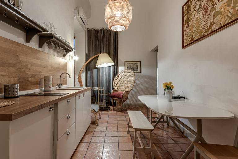 Cucina luminosa con pavimento in cotto e tavolo bianco